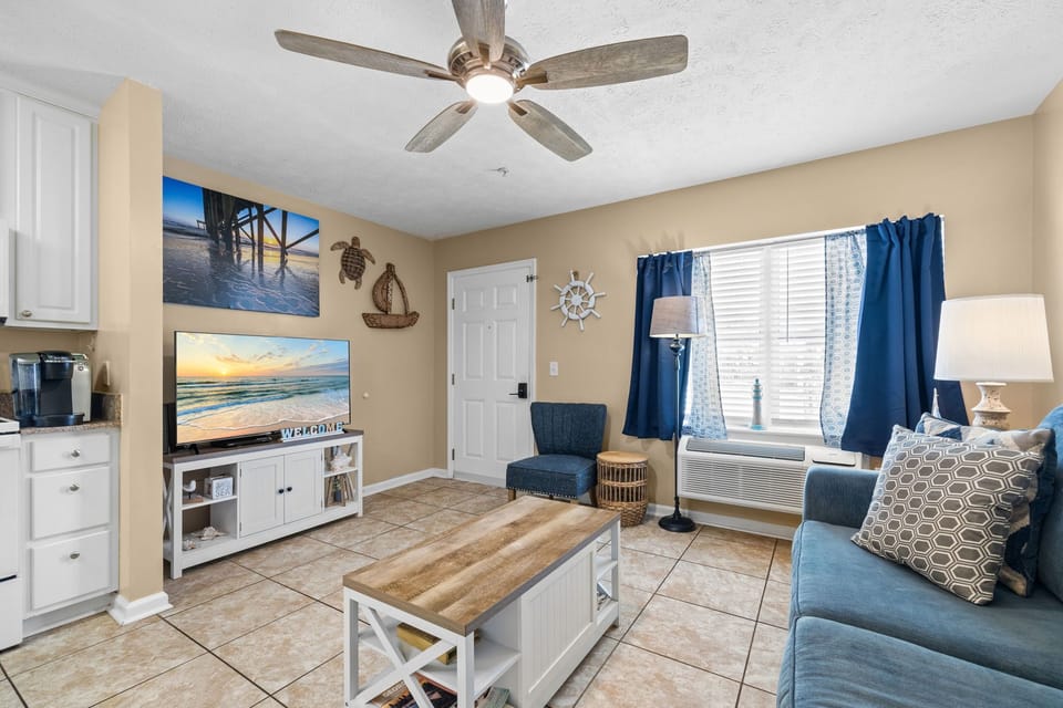Cozy living room with coastal decor and natural light from the window.