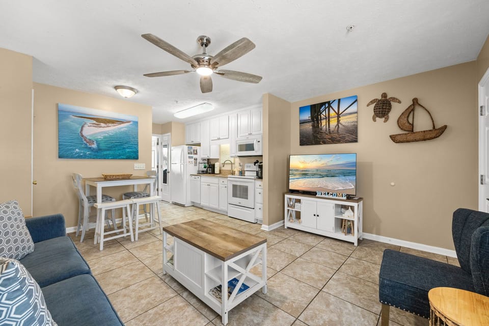 Open living area with coastal decor and a fully equipped kitchen.