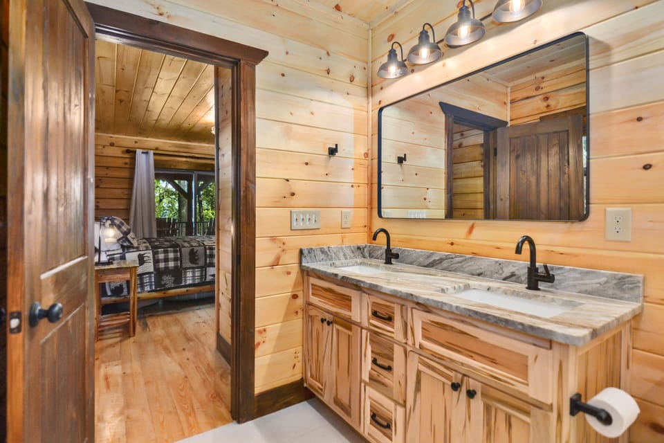 Master bathroom with dual vanity and views of deck 