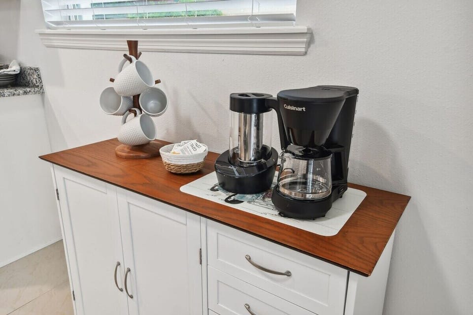 Coffee Station equipped with mugs, tea bags, instant coffee, half & half, sweet & low and sugar. Iced coffee maker and hot dripped coffee maker. 