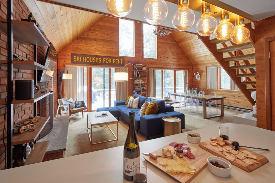The open-plan area flows from kitchen to living room to deck via glass doors.