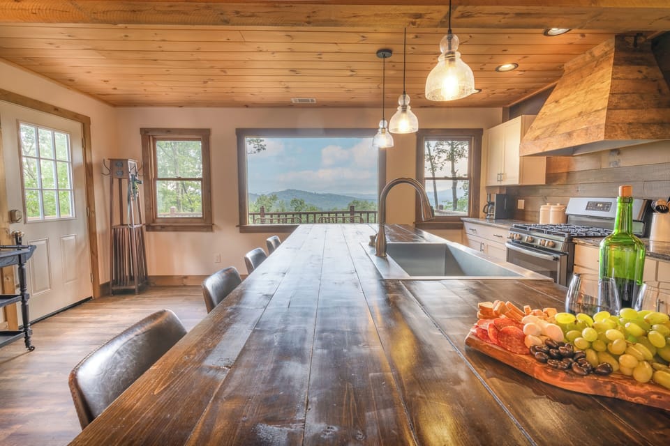 Open-concept kitchen with 4 barstools, views, table for 4, and living room