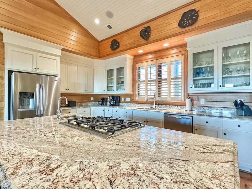 A large chef's kitchen with a granite island large enough for food preparation and seating.