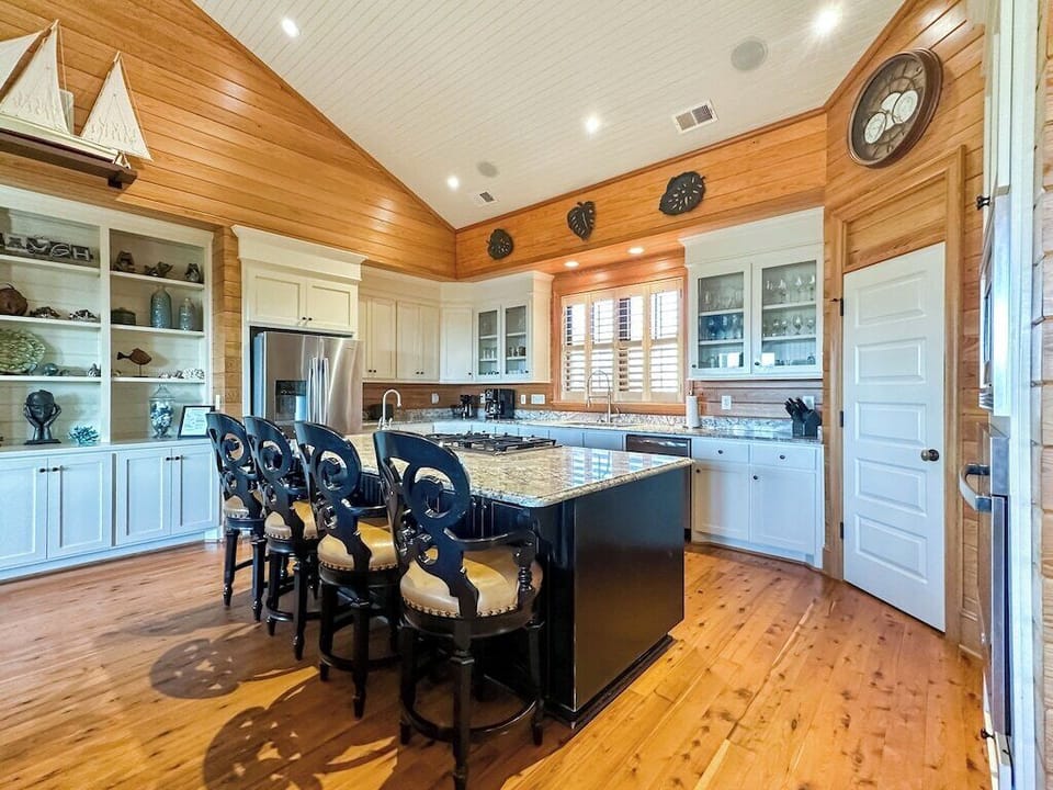 A large chef's kitchen with a granite island large enough for food preparation and seating.