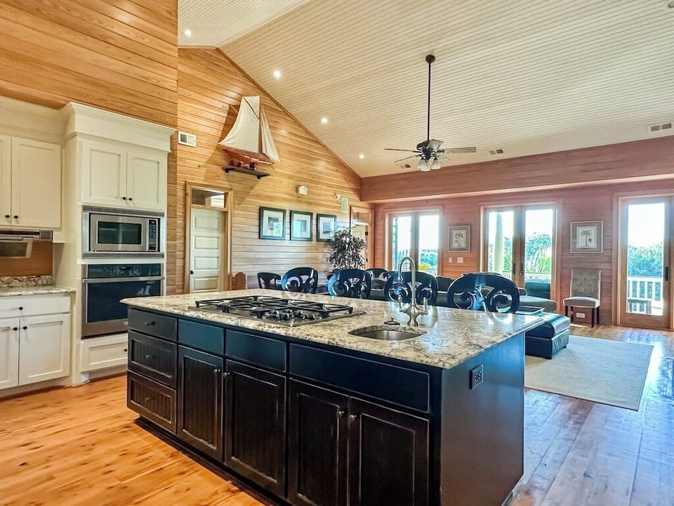 A large chef's kitchen with a granite island large enough for food preparation and seating.