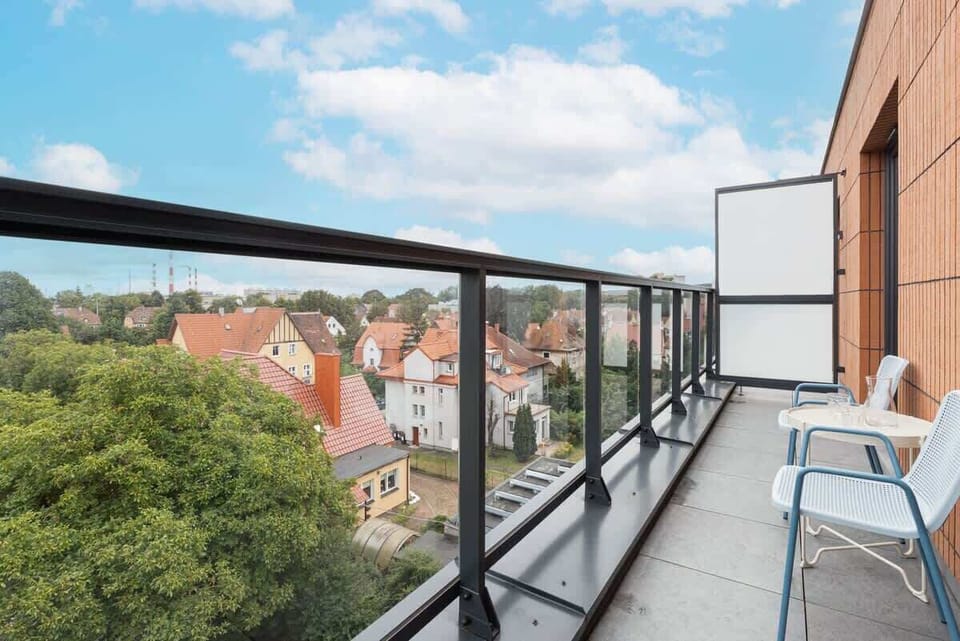 A balcony with a seating area and beautiful views of the historic rooftops in the area.

