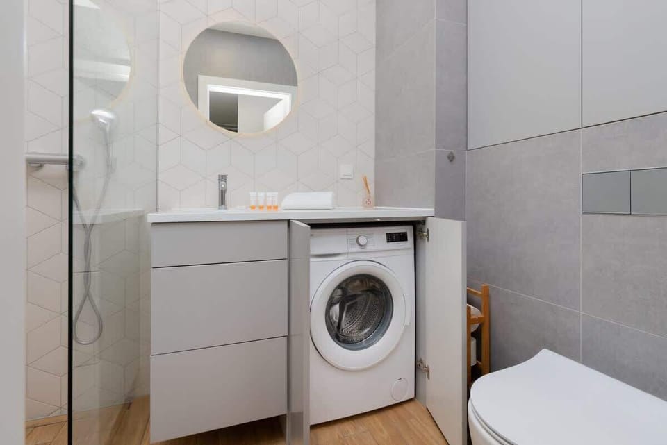 A bathroom equipped with a washing machine for added convenience during longer stays.







