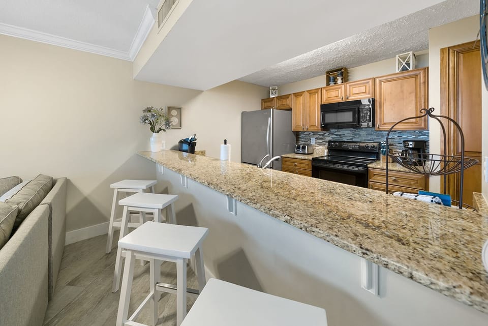 Your fully equipped kitchen features granite countertops, modern appliances, and a breakfast bar perfect for morning coffee or casual meals.