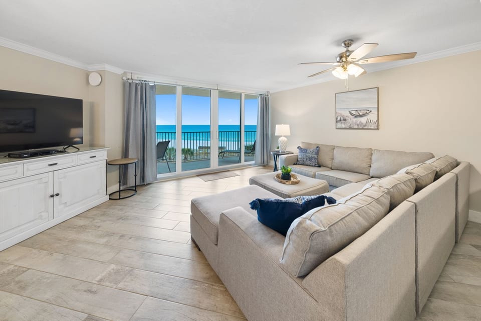 Sink into your spacious sectional and watch the turquoise waves through floor-to-ceiling windows—your oceanfront living room awaits.