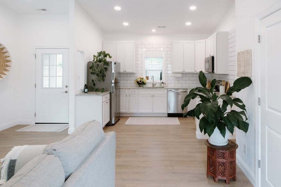 Bright and inviting open-concept living space filled with natural light, stylish décor, and cozy furnishings designed for relaxation and gathering.