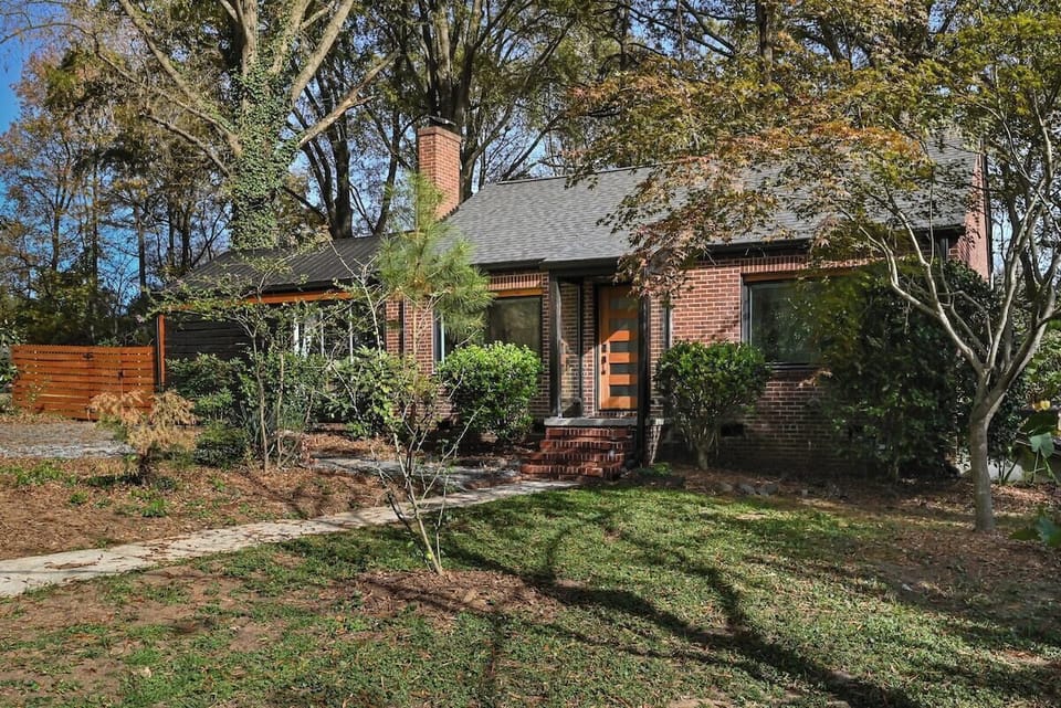 The Conservatory on Main welcomes you with its 1950s brick charm, fenced yard, and garden path—just steps from downtown Matthews.