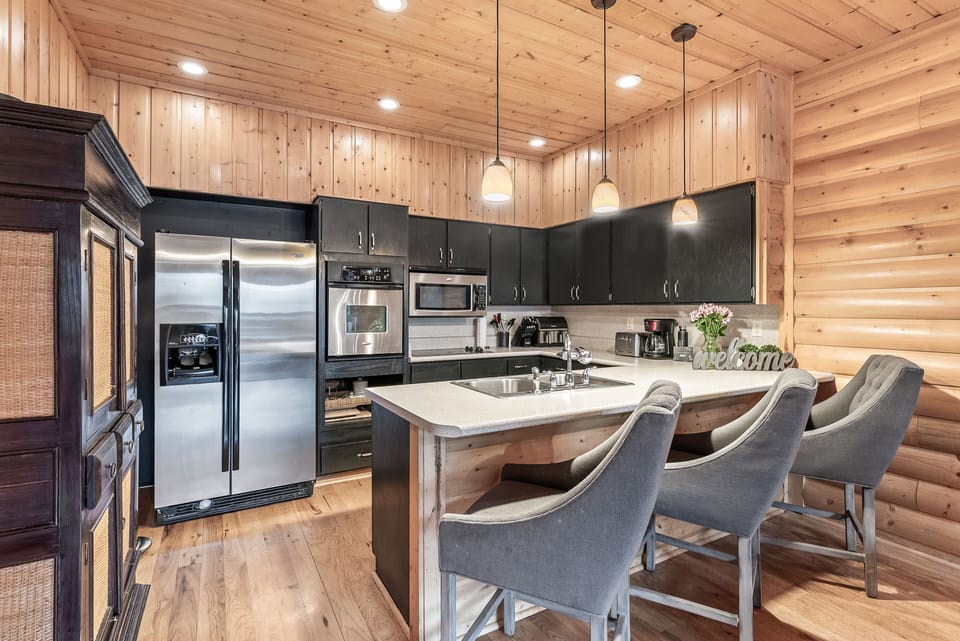 - Cook meals in the modern kitchen with stainless steel appliances  
- Spacious island with bar seating for casual dining moments  
- Warm wood finishes blend with sleek updated cabinetry