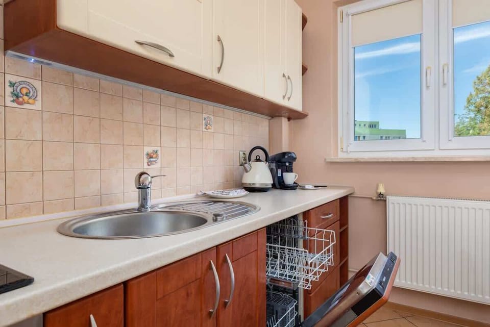 Another view of the kitchen, emphasizing its functional design with built-in appliances and a compact dining setup.

