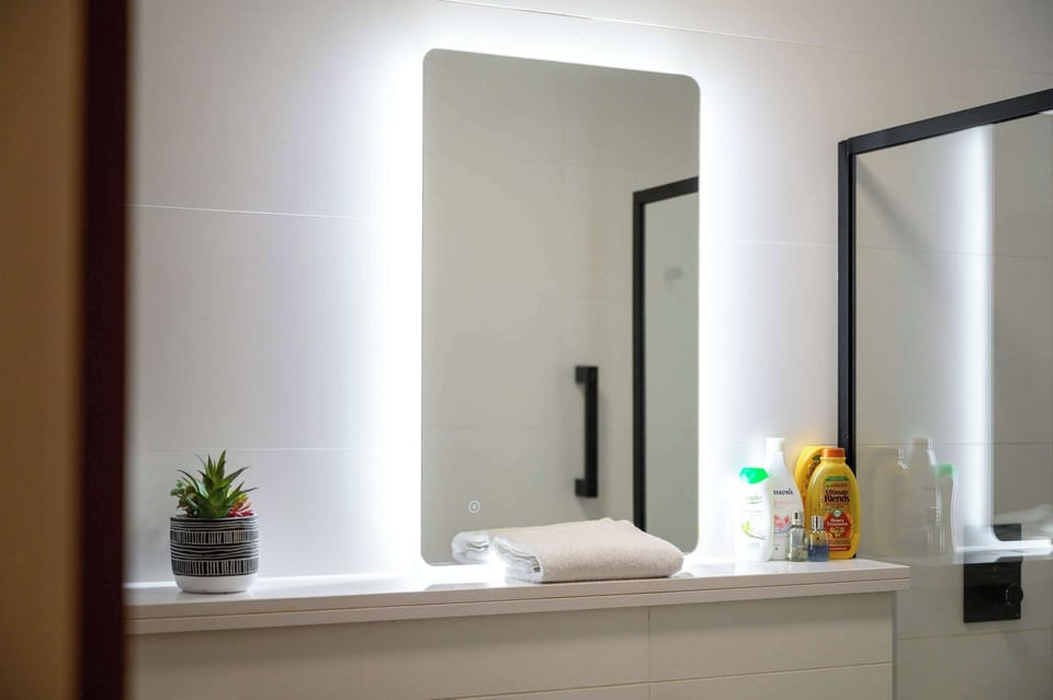 Modern bathroom with backlit mirror, quality fittings and complimentary toiletries