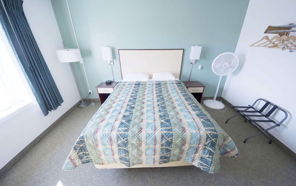 Bright bedroom with double bed, window and nightstand