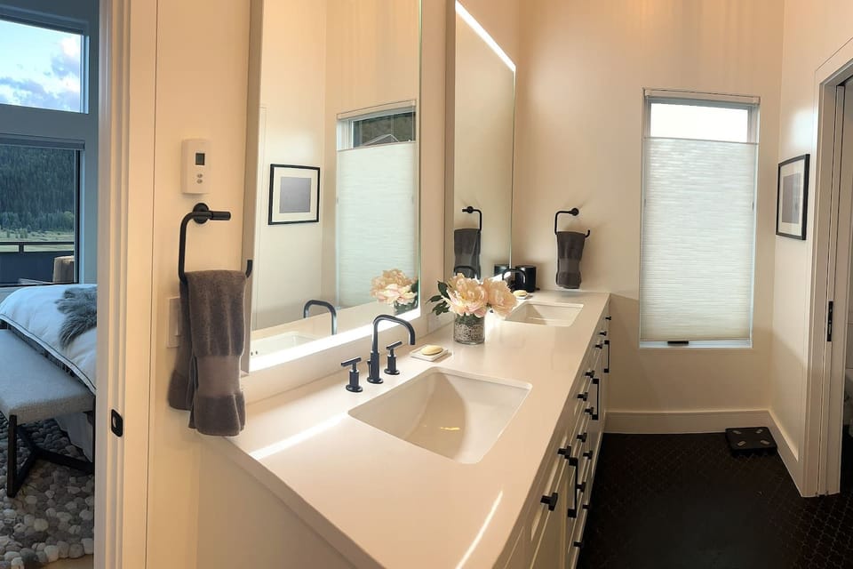 Primary suite bathroom vanity with double vanity and counter-to-ceiling lighted mirrors
