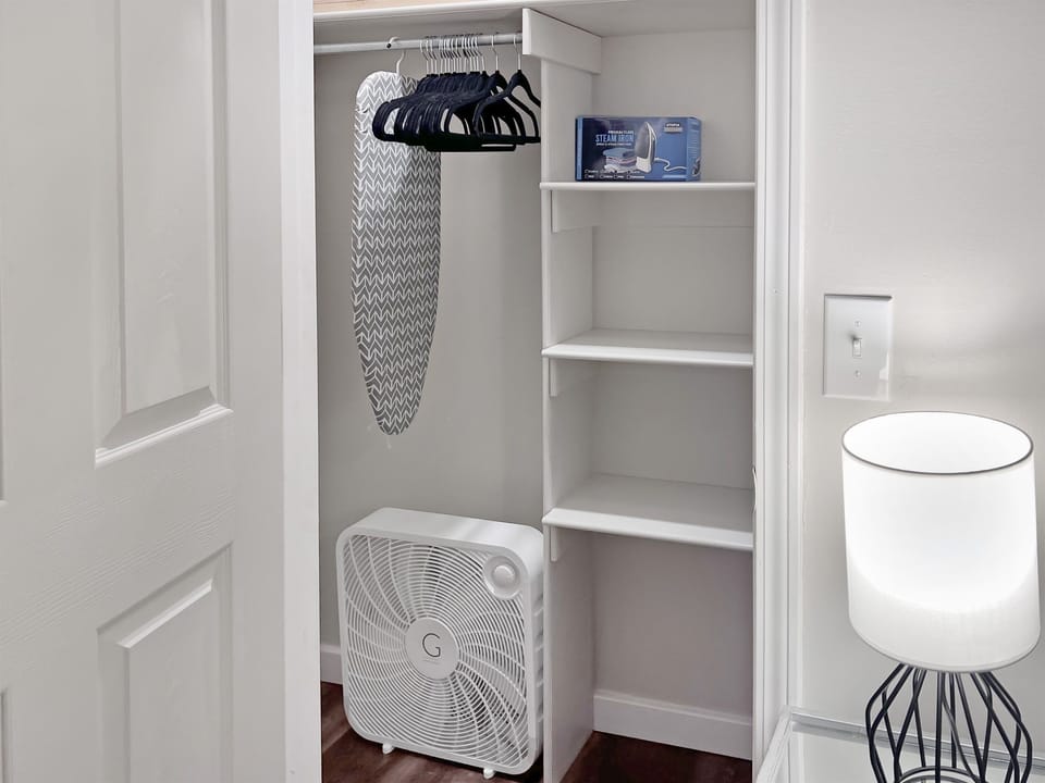 Closets have luggage rack, box fan, and hangers.