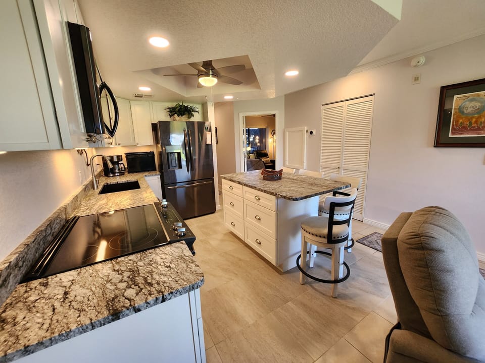 Kitchen from living room, granite countertops and 4 ceiling fans throughout unit