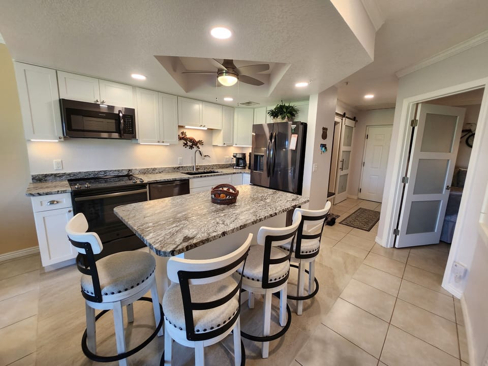 Kitchen with island, bedroom to the right and front door