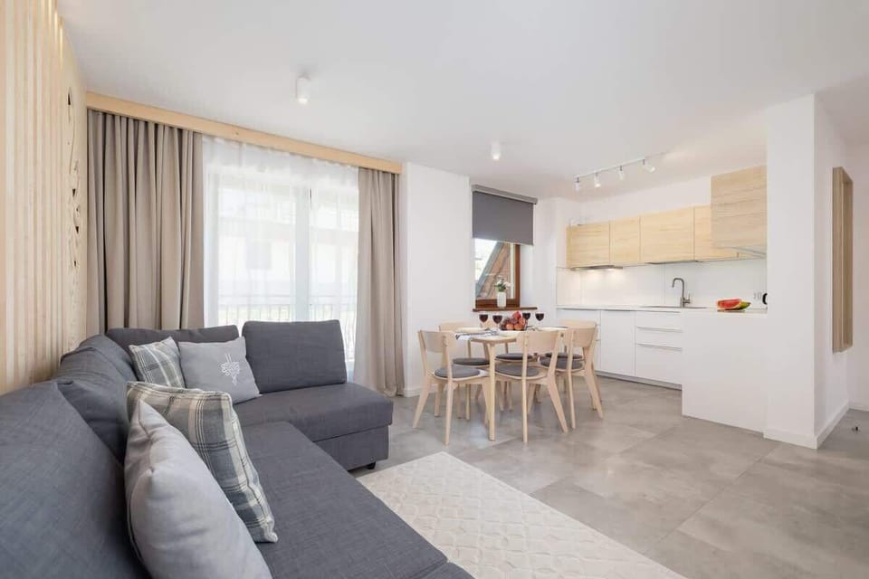 Another angle of the living and dining area, featuring a seamless transition between the kitchen, dining, and relaxation spaces.
