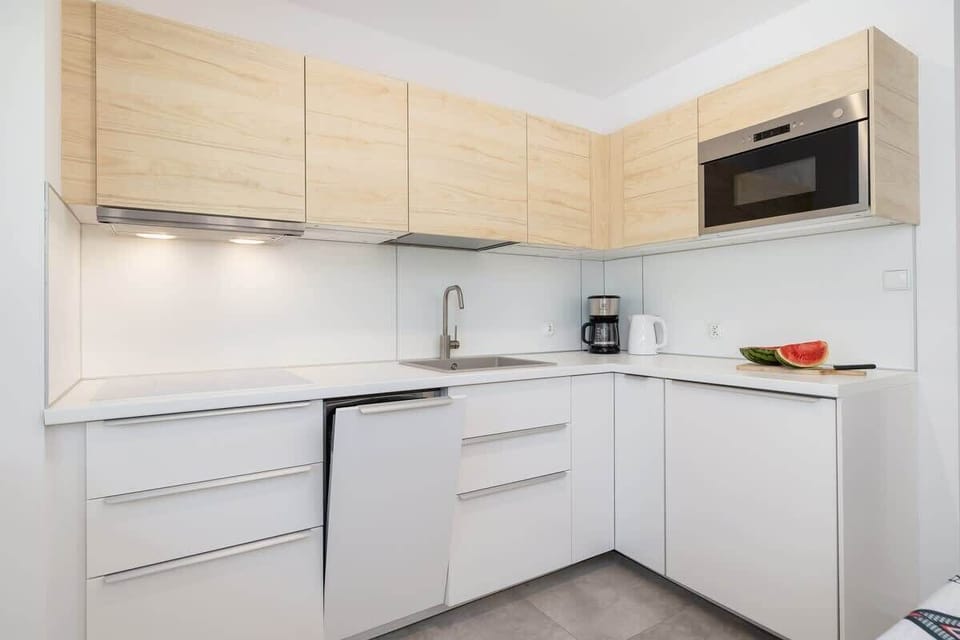 Another view of the kitchen, highlighting the clean lines, ample counter space, and minimalist design.

