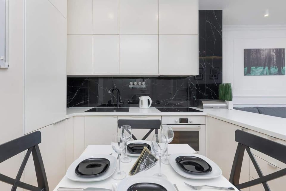 A modern kitchen with white and black finishes, featuring a functional cooking area with contemporary design elements.
