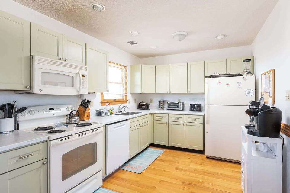Top Level: Fully stocked kitchen with refrigerator, oven, microwave, dishwasher, Keurig, blender, toaster oven, traditional 2-slice toaster, kettle, waffle maker and ample storage cabinet