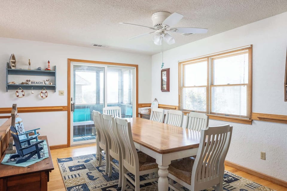  Top level: Dinig area featuring seating for 8 and an open-concept layout with direct access to the screened sun deck