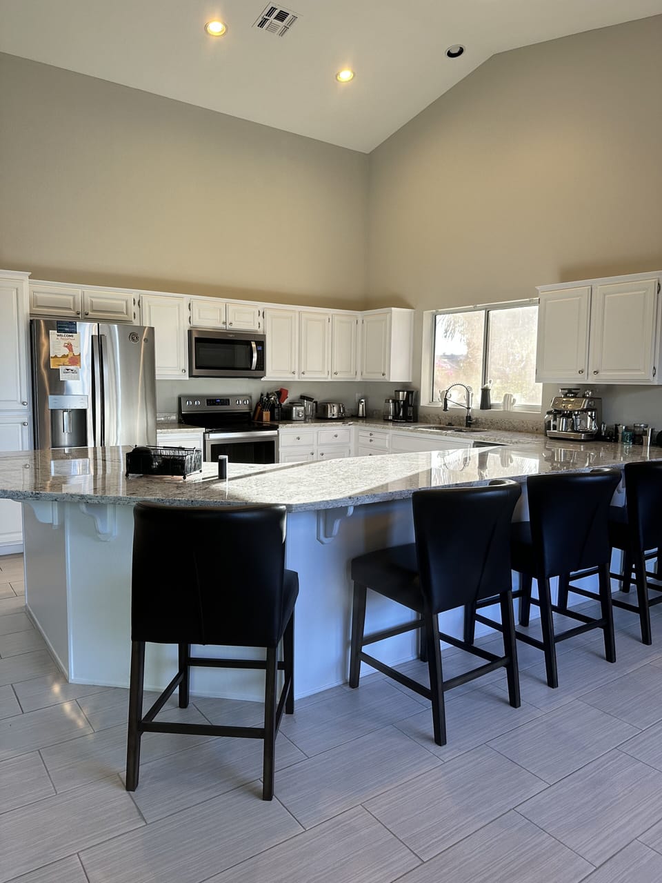 Large Updated kitchen with SS appliances,  Leather Stools, & lots of prep space