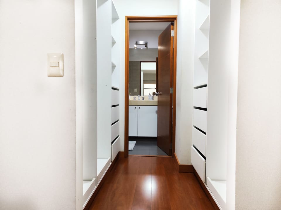 Walk-in closet with lots of storage space and corridor to ensuite bathroom