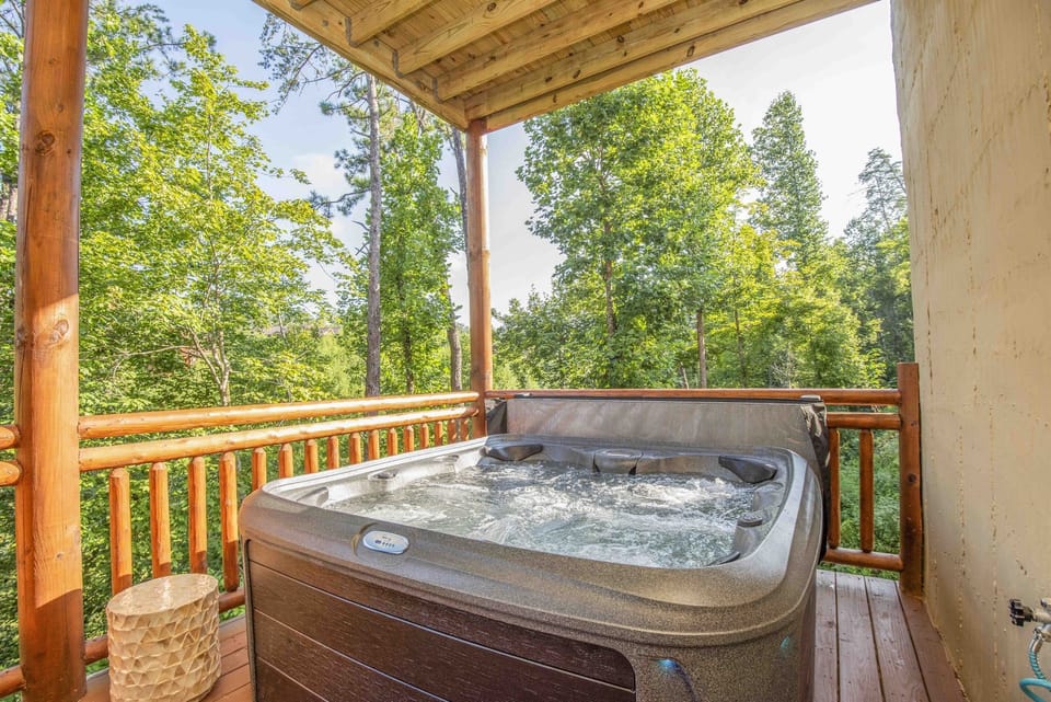 Expansive deck with a hot tub and stunning mountain views.