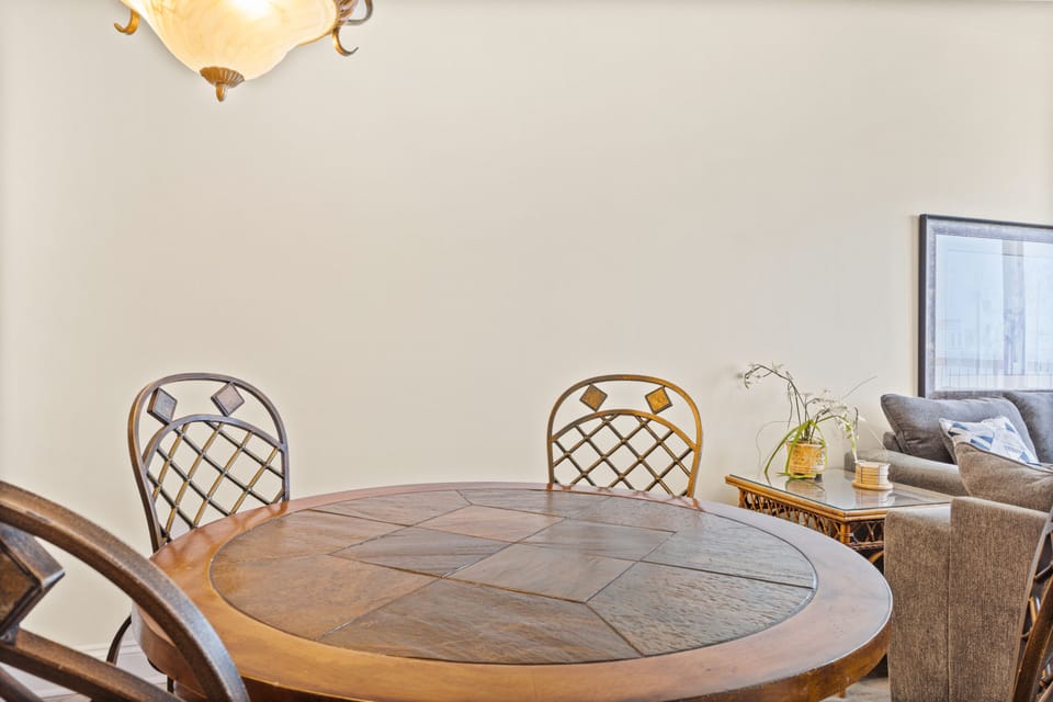 Dining Area - This inviting dining area seats four comfortably, offering a stylish setting to relish homemade dishes with a picturesque beach view. Includes 2 bar stool for extra seating.