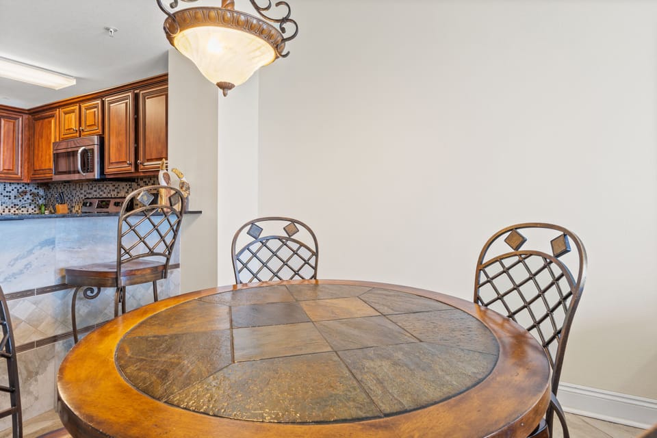 Dining Area - This inviting dining area seats four comfortably, offering a stylish setting to relish homemade dishes with a picturesque beach view. Includes 2 bar stool for extra seating.
