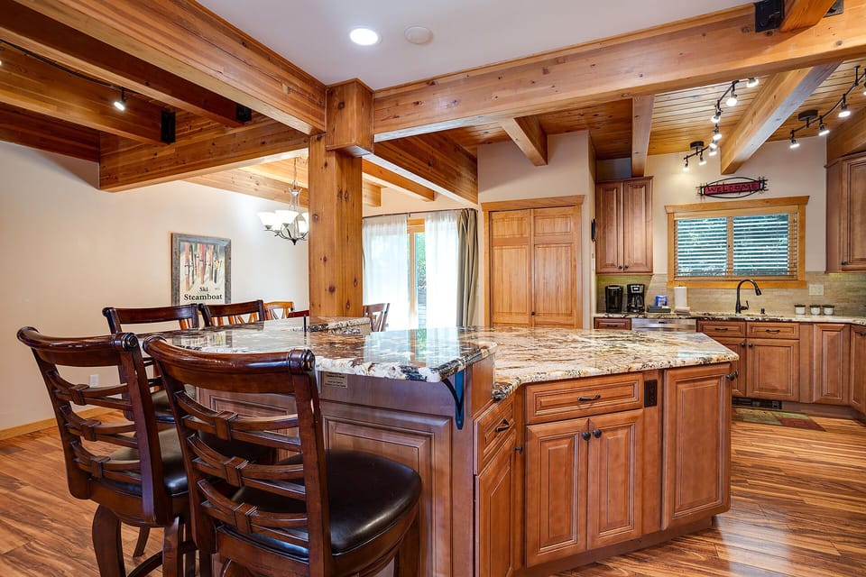 Gather around this stunning granite island where warm wood beams frame your culinary adventures and memorable conversations unfold.