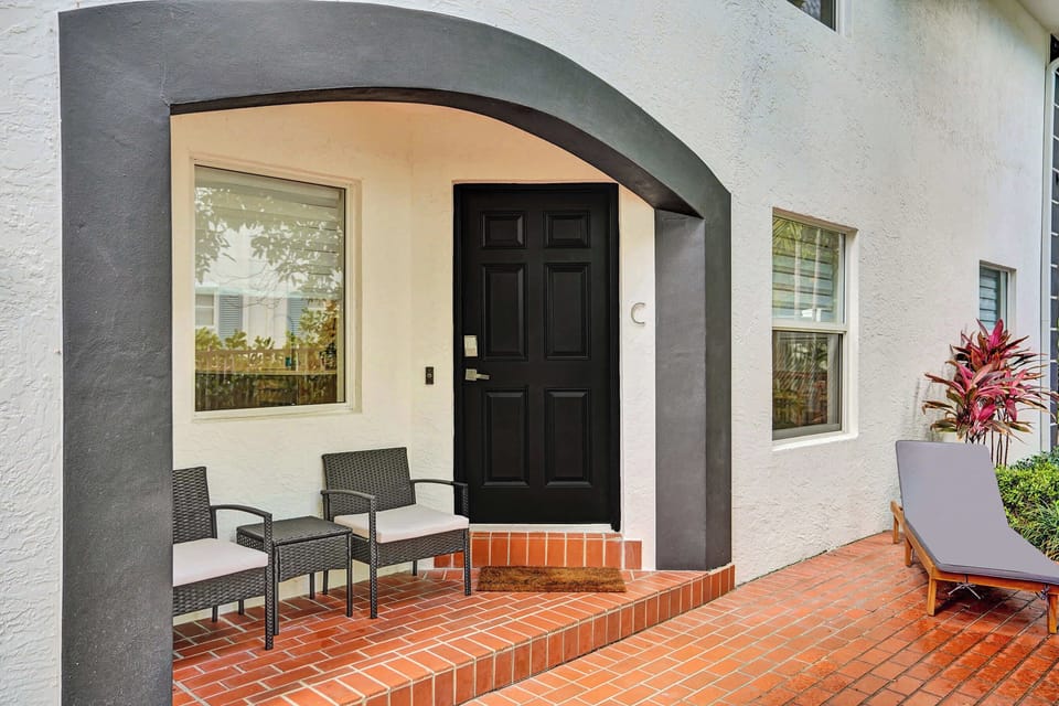 Entrance includes patio chairs and chaise lounge for relaxation.