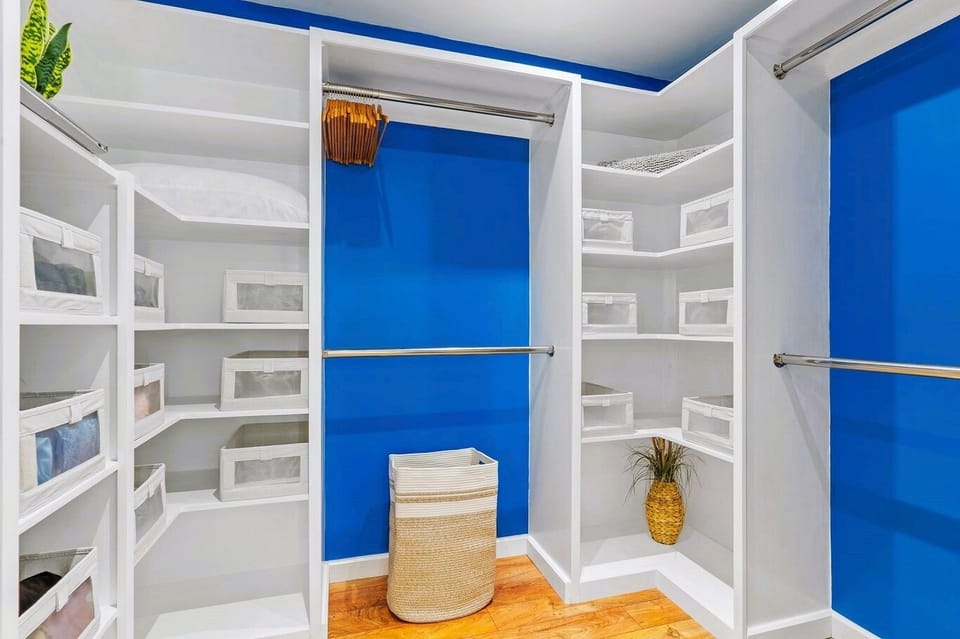 Master bedroom closet with wall mounted ironing board and iron
