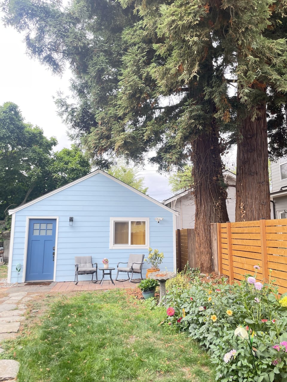Front of the home with seating and flower garden.
