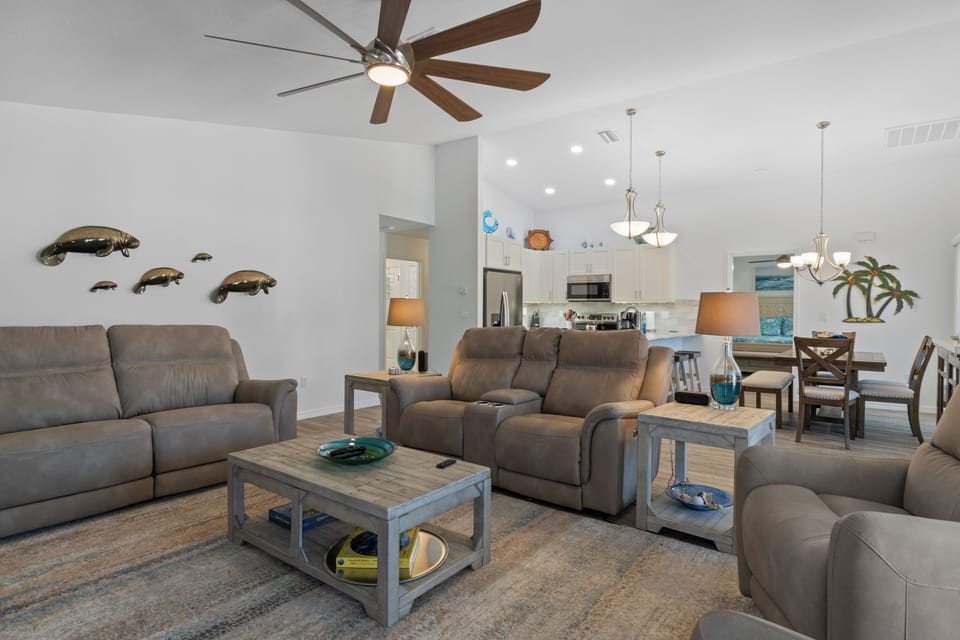 The living room has a 75-inch TV and a sofa with comfortable reclining seats