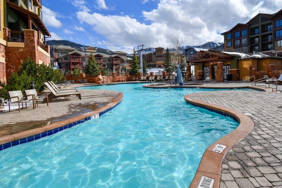 Dive into relaxation in the shimmering pool, surrounded by stunning mountain views.