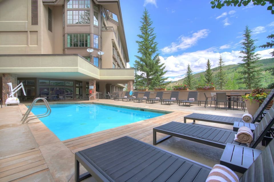Refresh and relax by the pristine pool, surrounded by lush greenery and sunny skies.