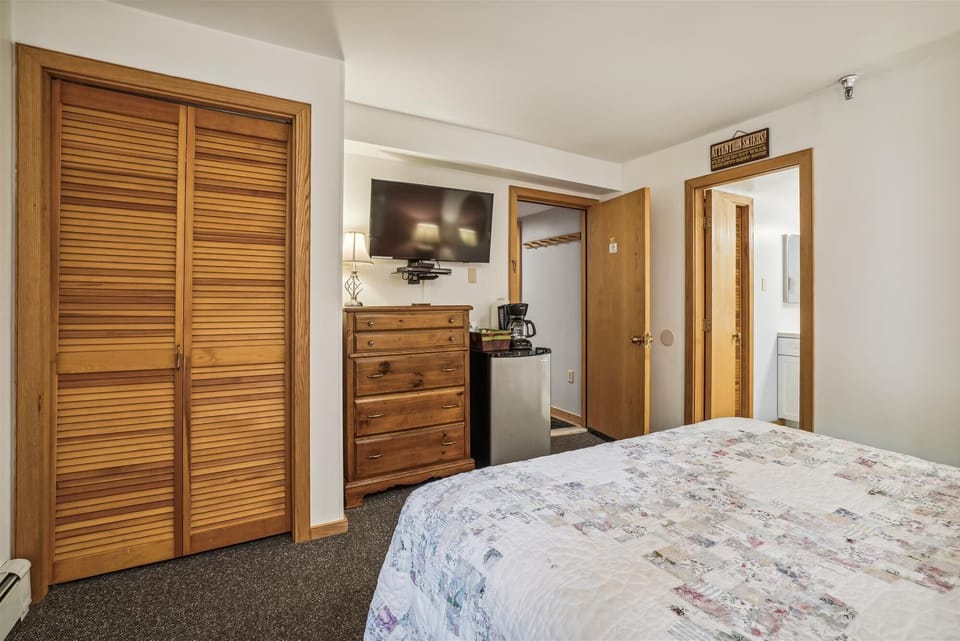 This bedroom has a mini fridge and coffee pot.