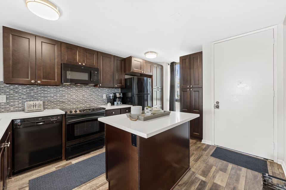 An elegant, open-concept kitchen featuring custom cabinetry, beautiful granite countertops, and a central island.