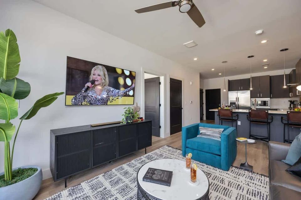 Welcome to a bright and open concept living room that exudes modern elegance. Designer furnishings enhance the sophistication of the space, while a smart TV provides entertainment options and a pull-out couch.