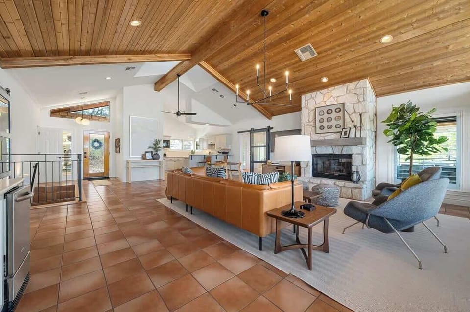 The main landing houses an open living room and kitchen along with access to the primary bedroom, grand living room, and expansive patio.