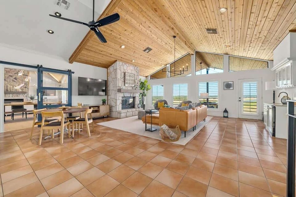 This living room offers a seating area, TV, small breakfast table, the kitchen. Doors lead to the primary bedroom and grand living room.