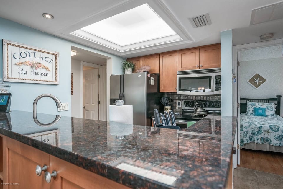 Full, modern kitchen with plenty of cabinets fully stocked with pots, pans and dishes.