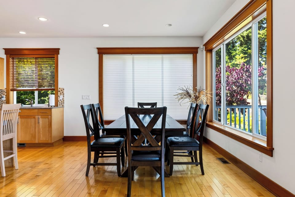 Share meals around the six-seat dining table, surrounded by warm wood finishes and abundant natural light.