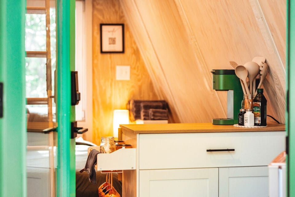 Enjoy simple cabin mornings with coffee, cooking basics, and a snug sleeping nook just steps away