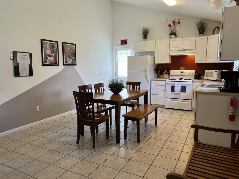 The Federal House Apartment 2 dining  table with seating for six. The exit door on the  left leads to the back deck and grill area.