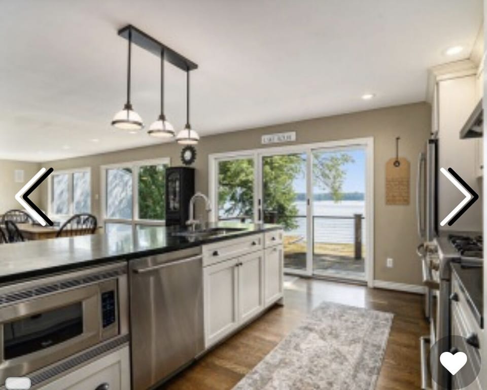 Kitchen with views of lake and access to deck with grill and eating space